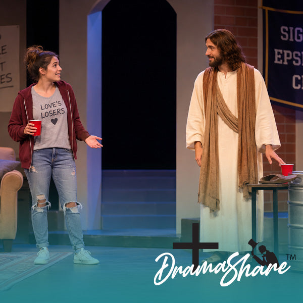 A theatrical stage scene with two actors: a woman in a gray 'LOVE'S LOSERS' graphic T-shirt, red jacket, and ripped jeans holding a red cup, and a man dressed as Jesus in a white robe with a tan drape holding a red cup. A 'DramaShare' watermark is visible in the lower right.