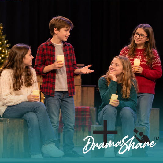 Four children in casual holiday clothing stand and sit on wooden steps, each holding a lit candle on a stage-like set with a dark curtain background. A DramaShare watermark appears at the bottom right.