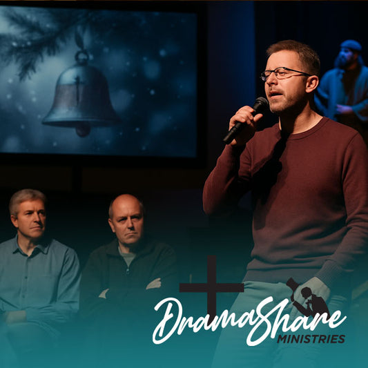 A man sings into a microphone during a Christmas stage play at church, while two others sit watching beside a nativity scene.